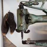 In una vetrina sono esposti un antico modellino di scarpa e la macchina da cucire di inizio Novecento appartenente al fondatore Domenico